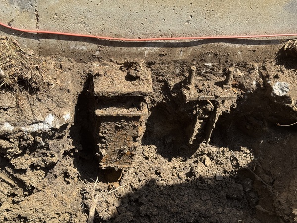 Multiple foundation repair pier brackets installed beneath an exterior foundation wall in Columbia, MO, during a helical pier foundation stabilization project completed by Spartan Ram Jack.