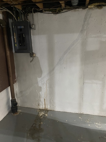 Basement foundation wall in an Overland Park, KS home showing a long diagonal crack with visible moisture staining and water seepage before crack repair and waterproofing services by Spartan Ram Jack Kansas City.
