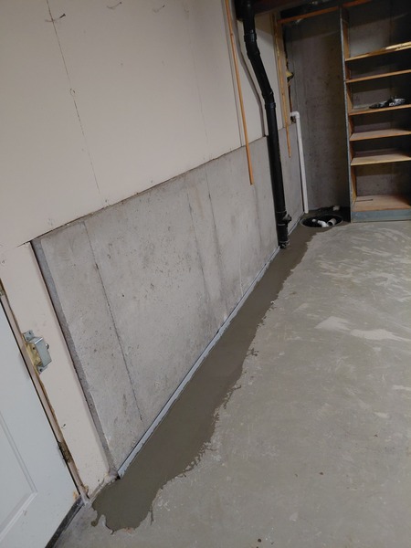 Interior basement waterproofing system installed along the floor-wall joint of a concrete foundation wall in Lee's Summit, MO.